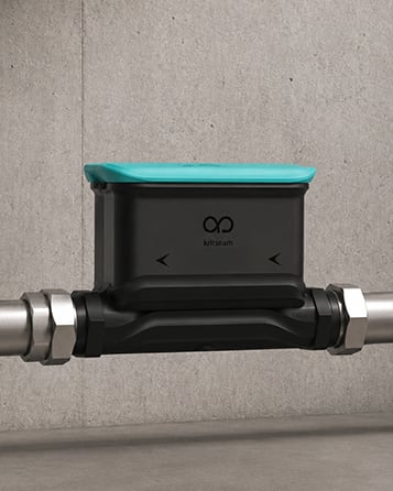 A Dhaara Pulse ultrasonic meter fitted onto the pipe.